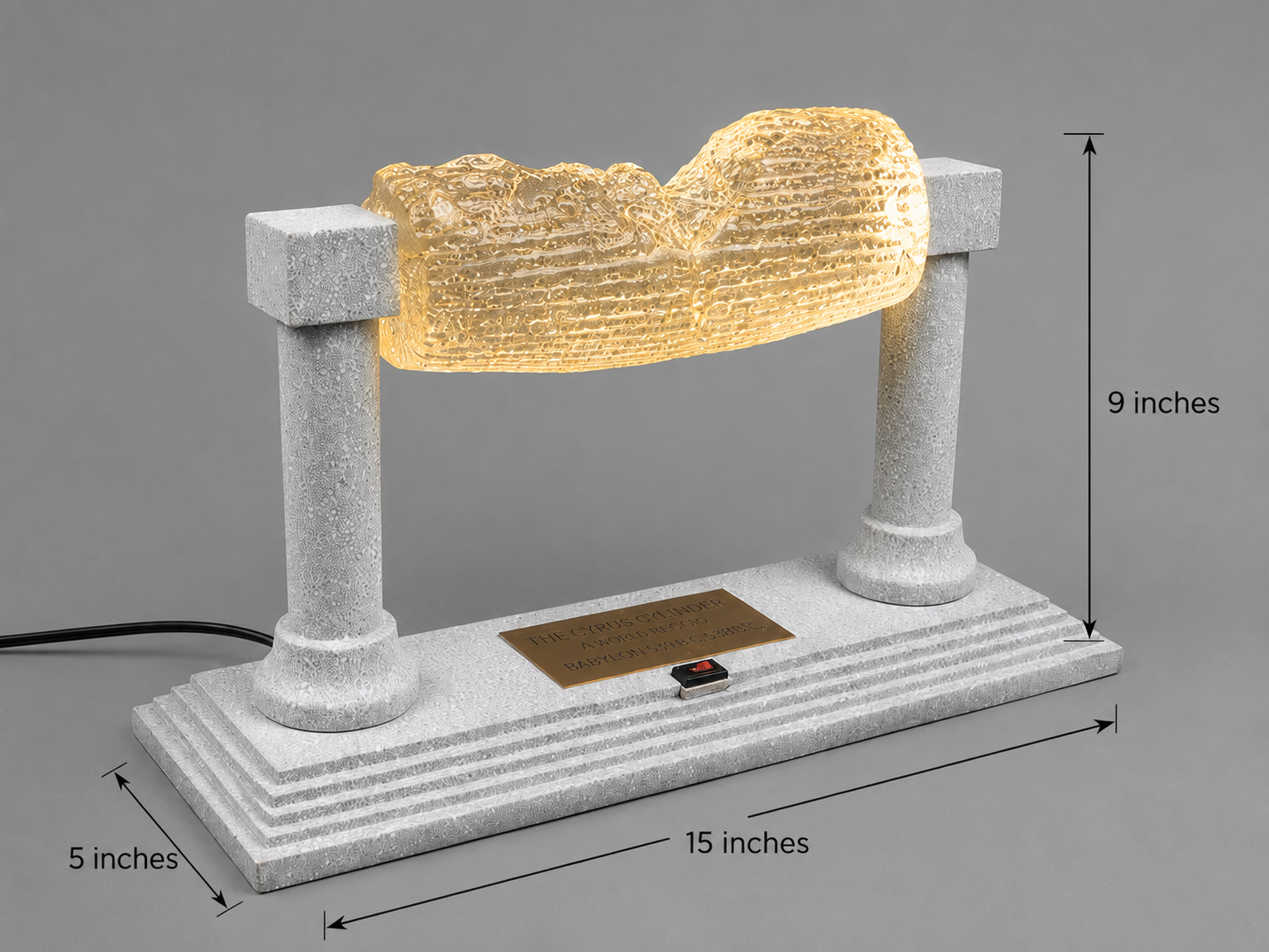 Cyrus Cylinder illuminated display with dimensions showing 15-inch width, 5-inch depth, and 9-inch height.