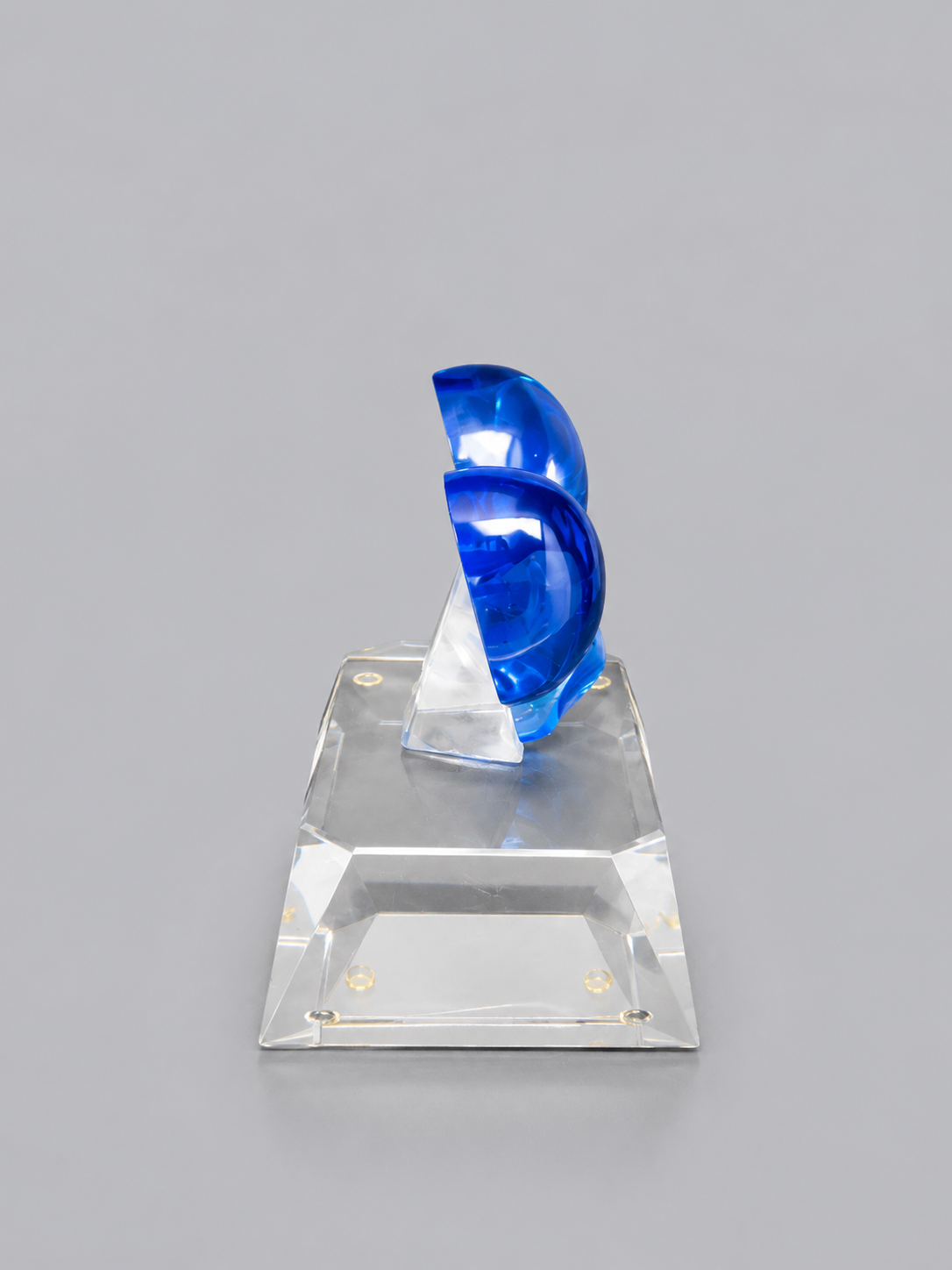 Opposite side view of the blue crystal bow and clear rectangular base, showing the bow’s thickness and mounting support.