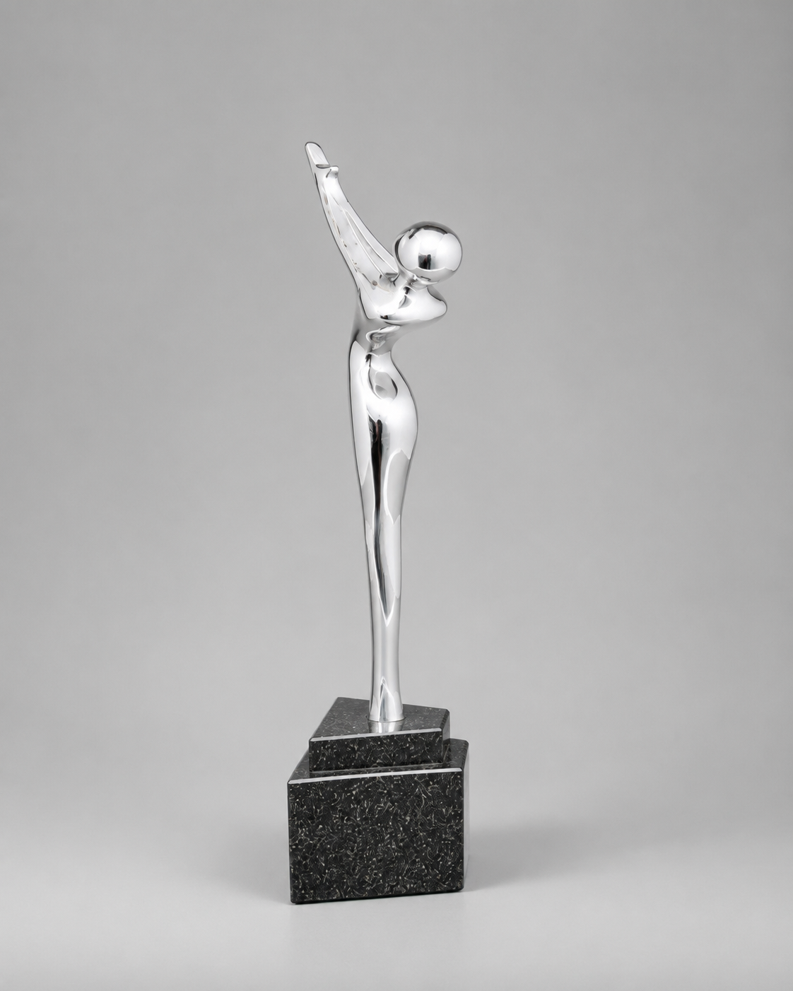 Angled side view of a reflective silver abstract figure with one arm raised, mounted on a black base.