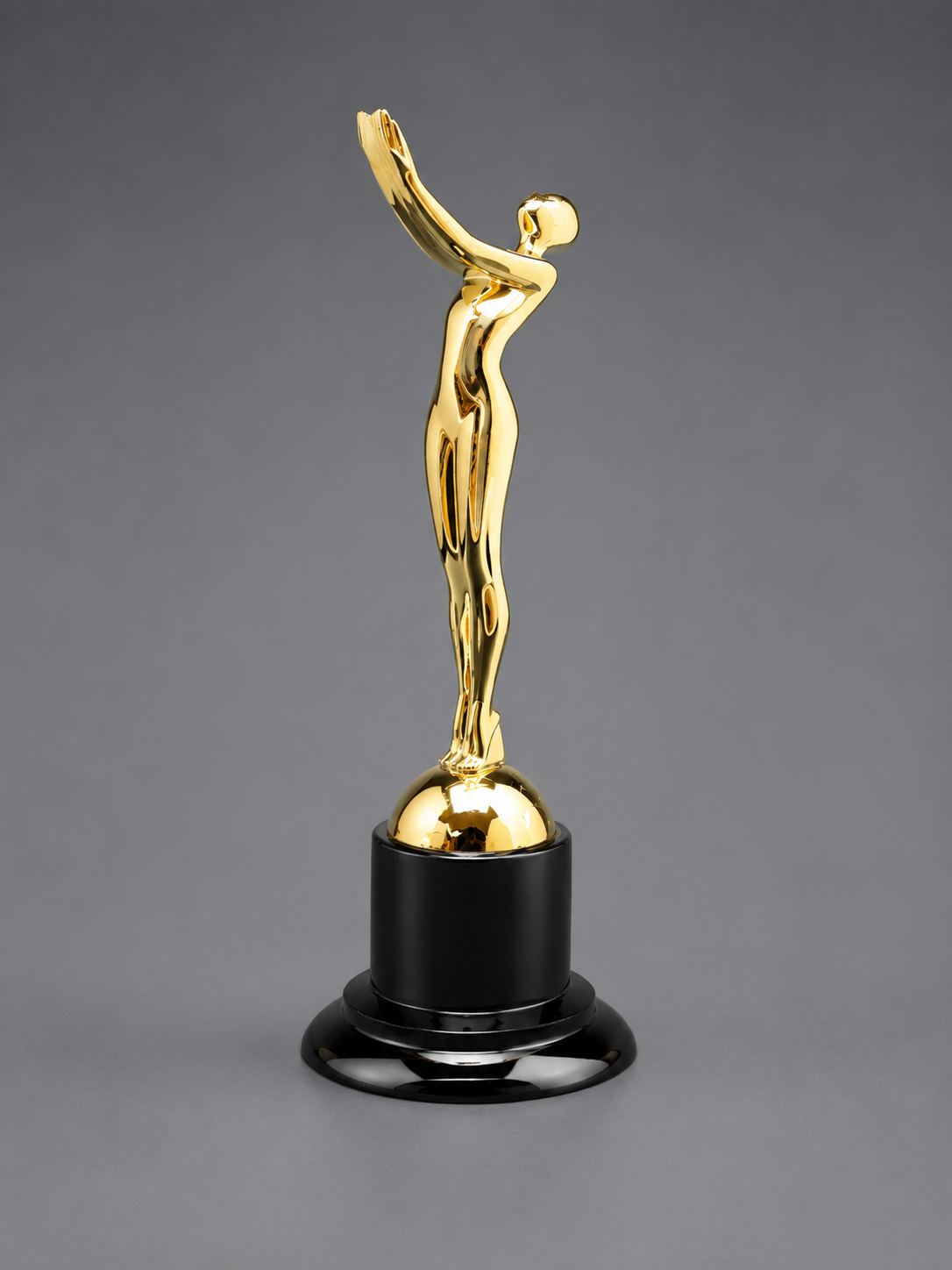 Victory Motion Gold Trophy with a metallic gold finish, modern abstract figure, and glossy black pedestal base on a neutral gray background.