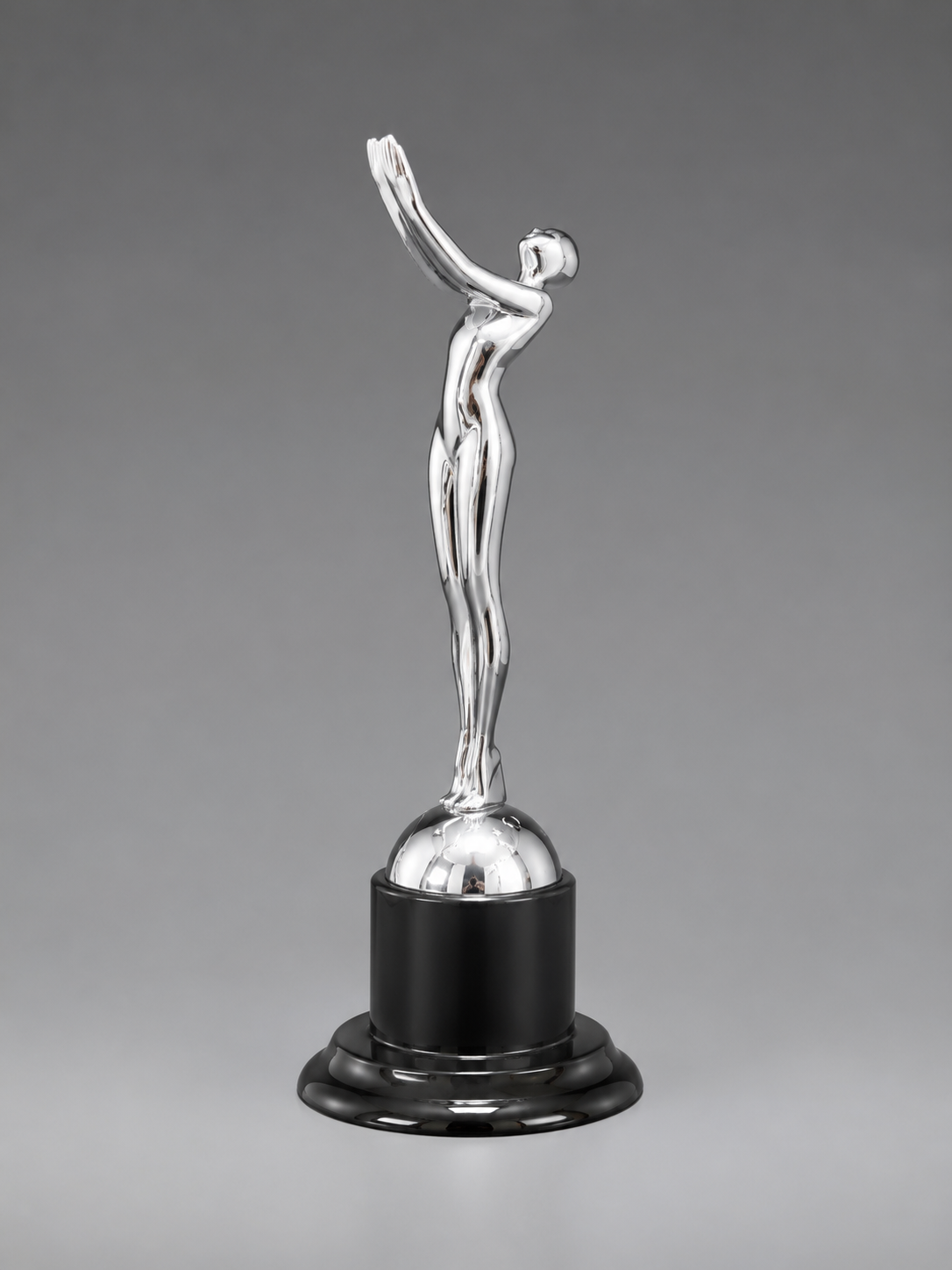 Victory Motion Silver Trophy featuring a polished chrome finish, abstract victory figure, and glossy black pedestal base on a gray studio background.