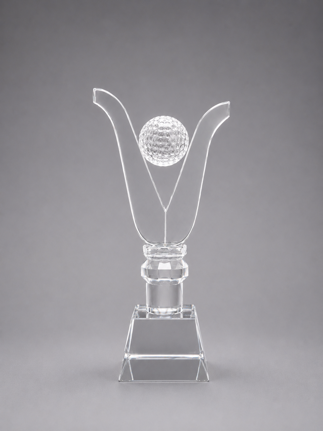 Clear crystal trophy with a golf ball design on a gray background