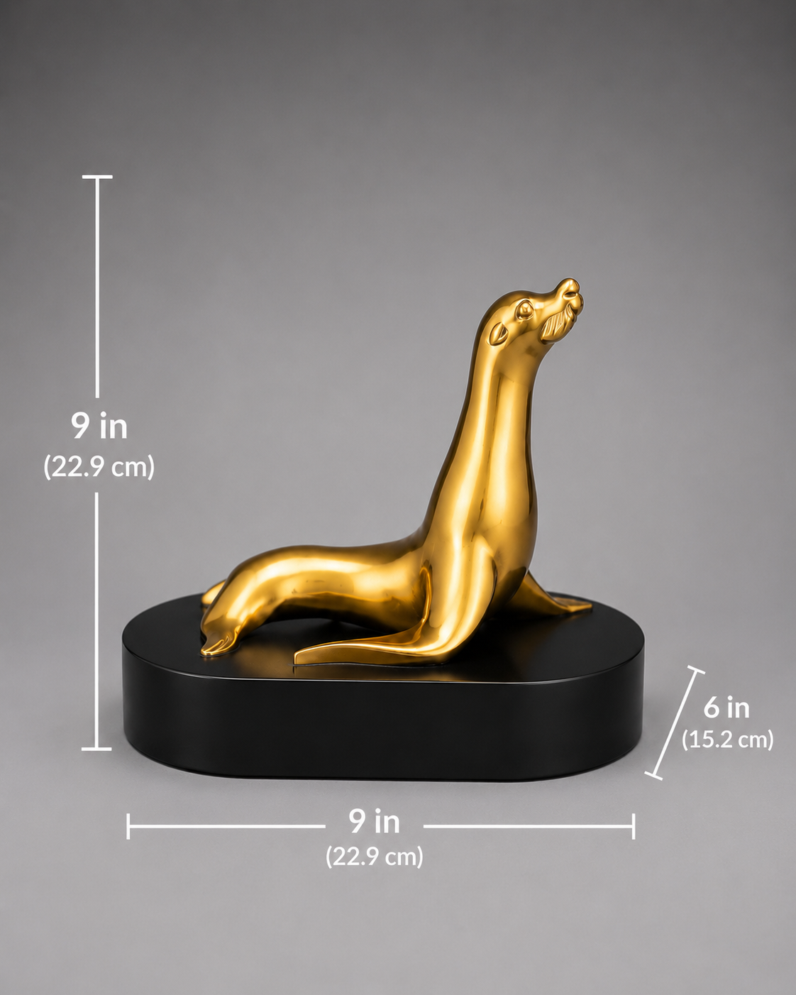 Bronze seal sculpture on a black base with measurements indicated. 9 inch height. 9 inch bae length. 6 inch base width