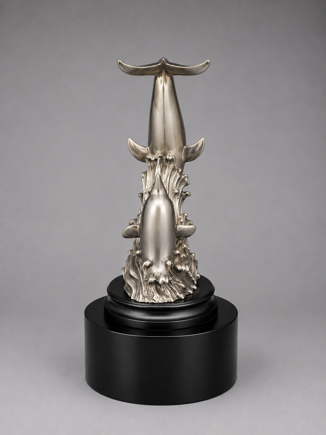 Silver award of a dolphin on a black base against a gray background