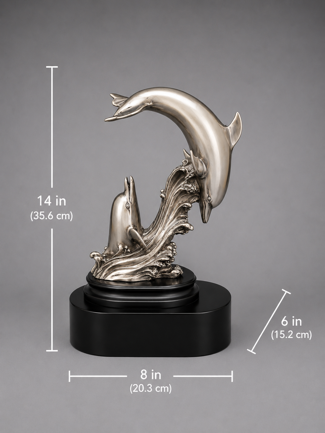 Silver dolphin sculpture on a black base with measurements indicated. 8 inch base length. 6 inch base width. 14 inch height.