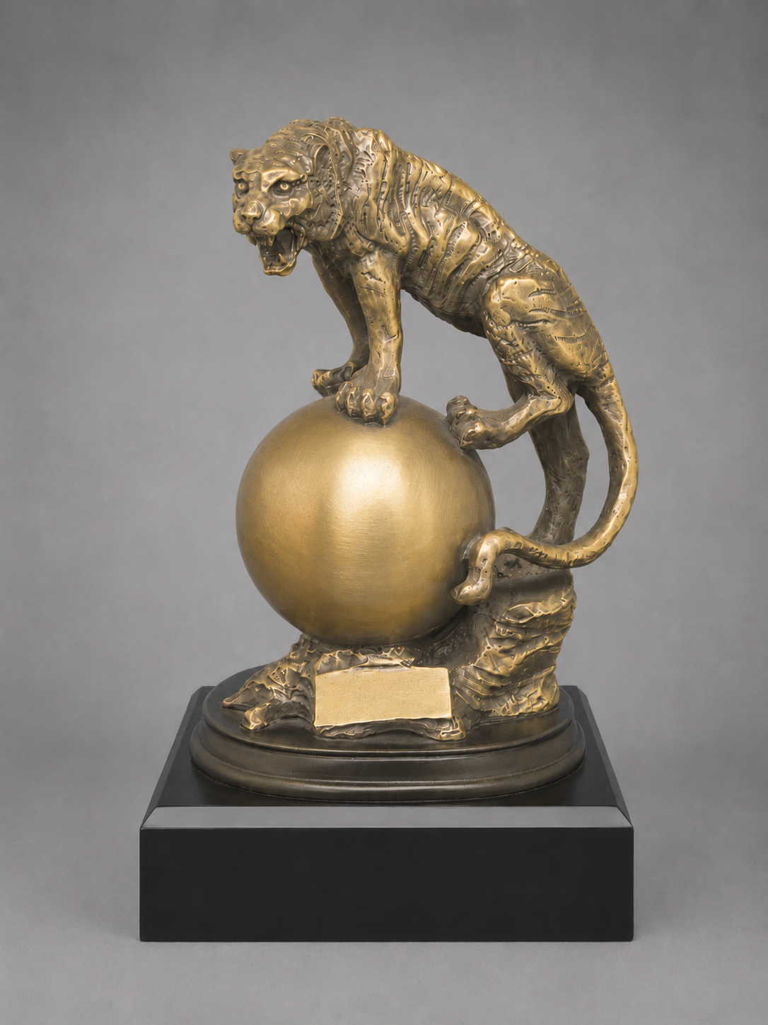Bronze sculpture of a tiger on a sphere with a gray background