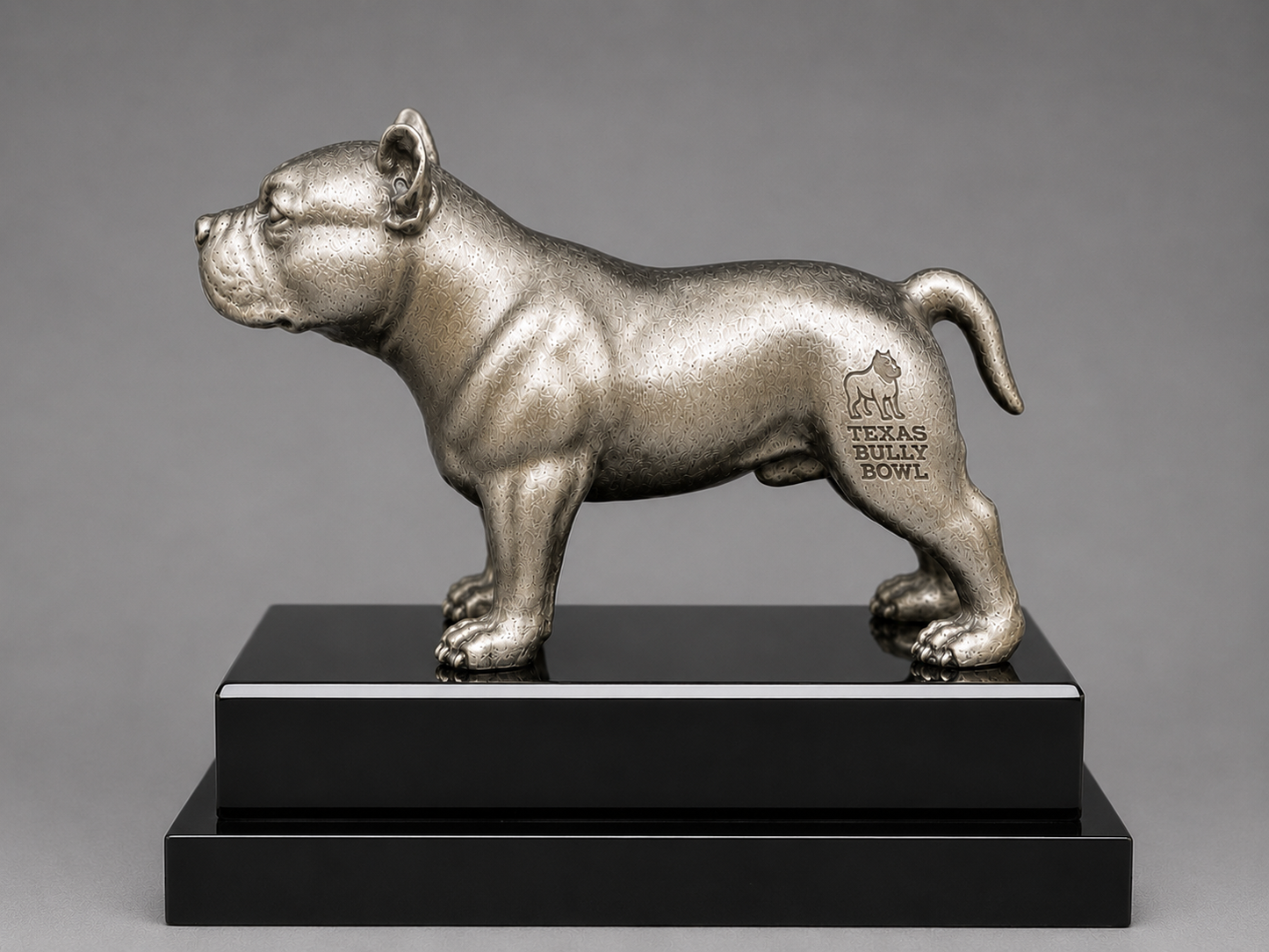 Silver statue of a bulldog on a black base with 'Texas Bully Bowl' text against a gray background