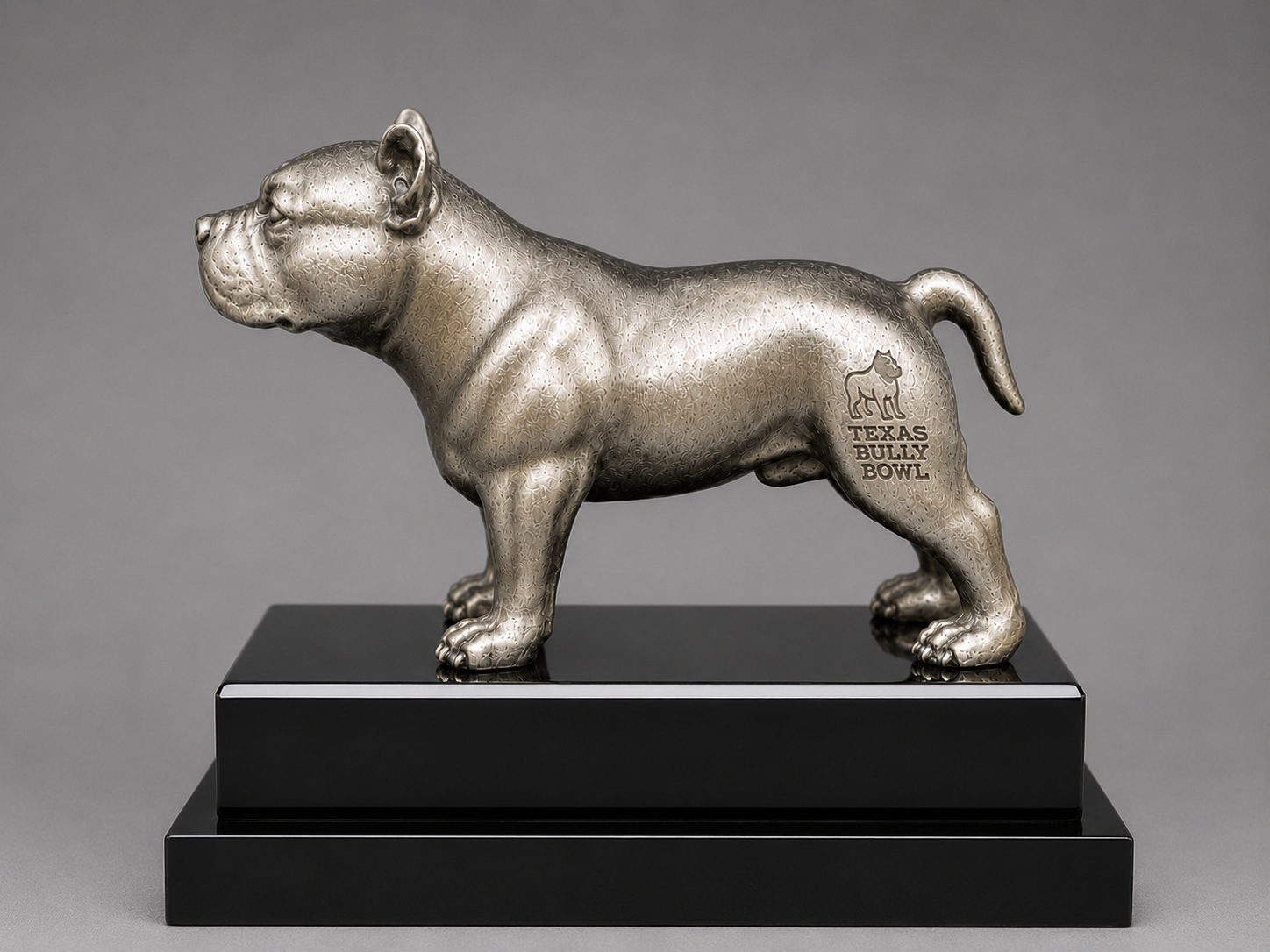 Silver statue of a bulldog on a black base with 'Texas Bully Bowl' text against a gray background