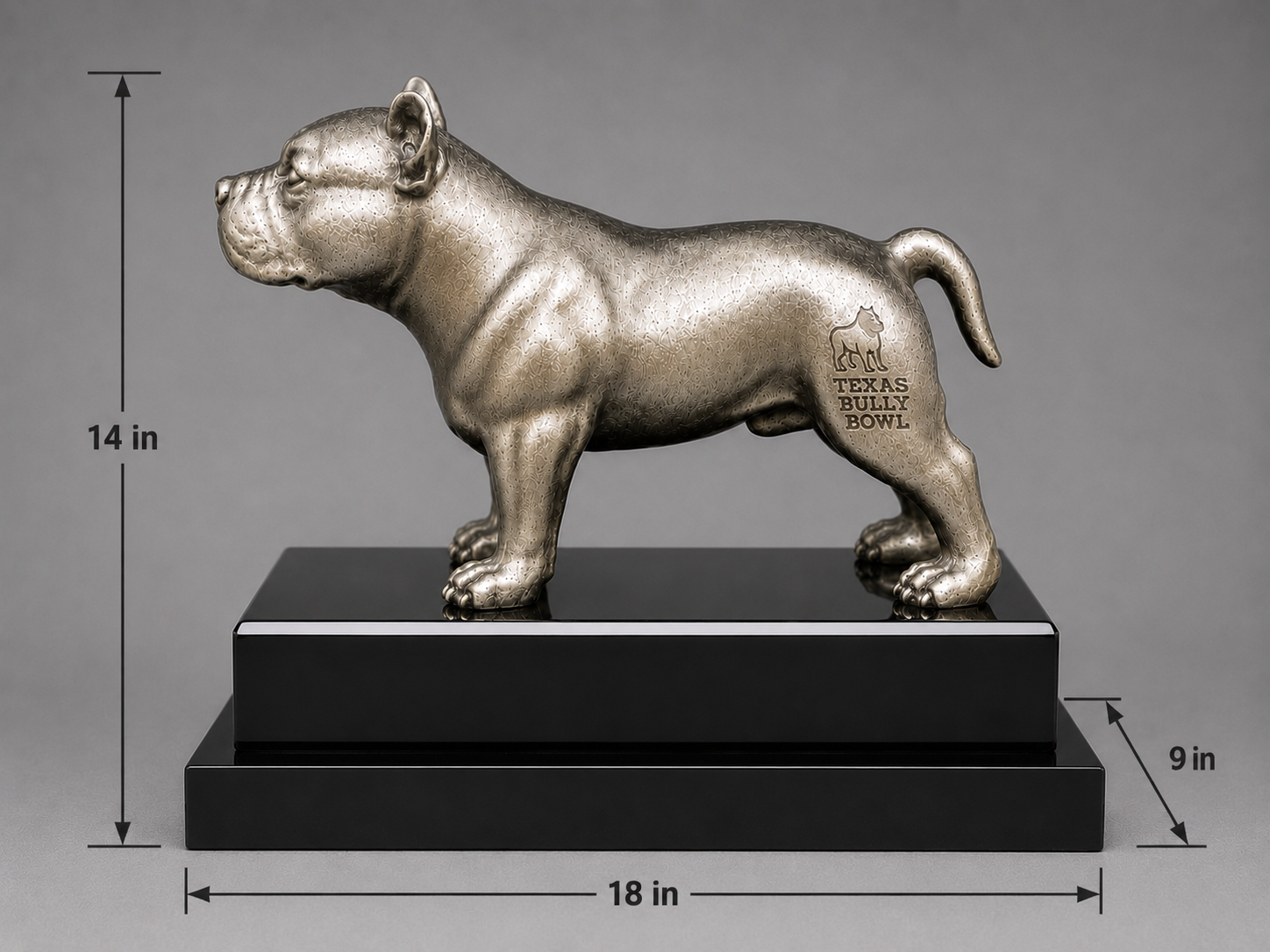 silver statue of a dog on a black base against a gray background with measurements. 14 inch height. 18 inch base length. 9 inch base width.