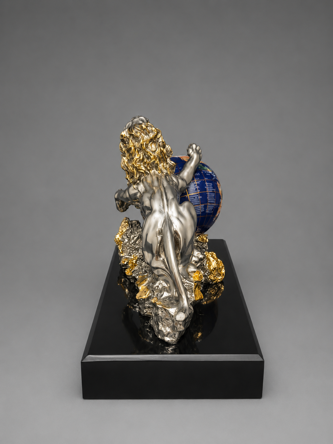 Decorative sculpture of a figure with a globe on a gray background