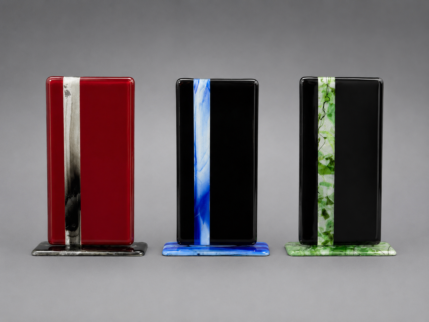 Three rectangular glass plaques with color stripes on a gray background