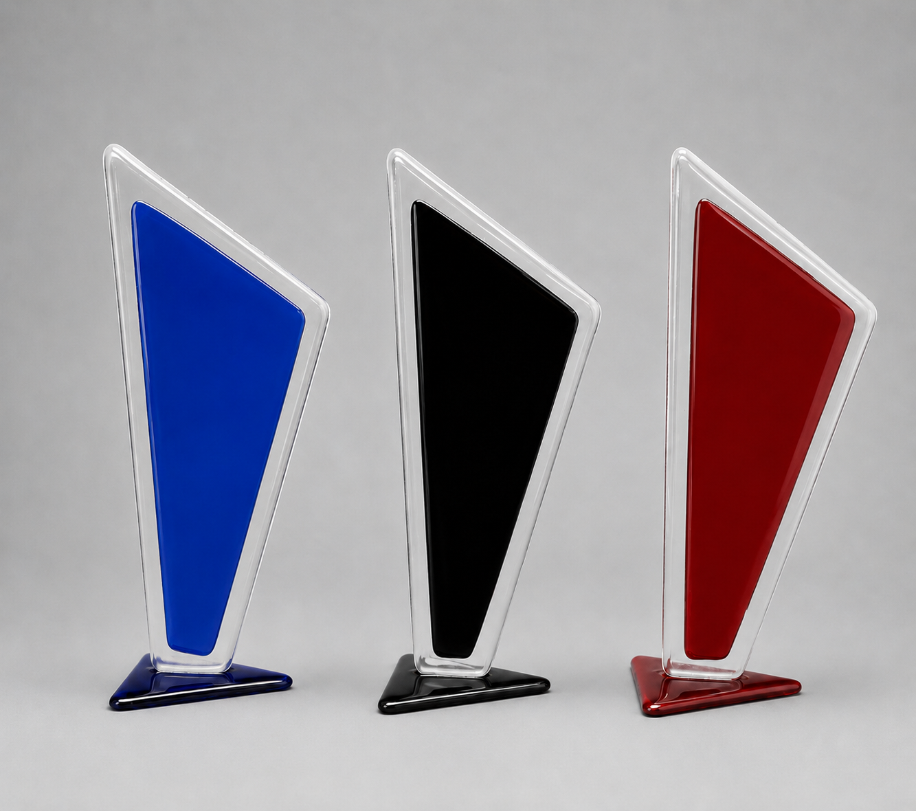 Three geometric art pieces in blue, black, and red on a gray background on a stand