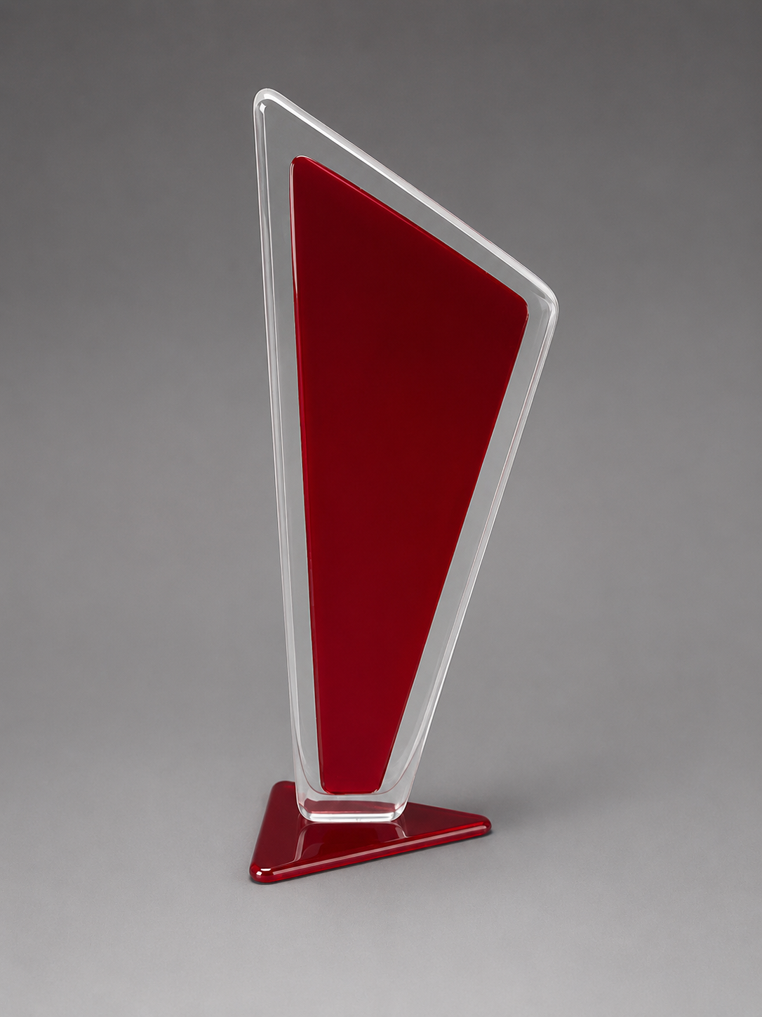 Tall, red and clear triangular plaque on a gray background.